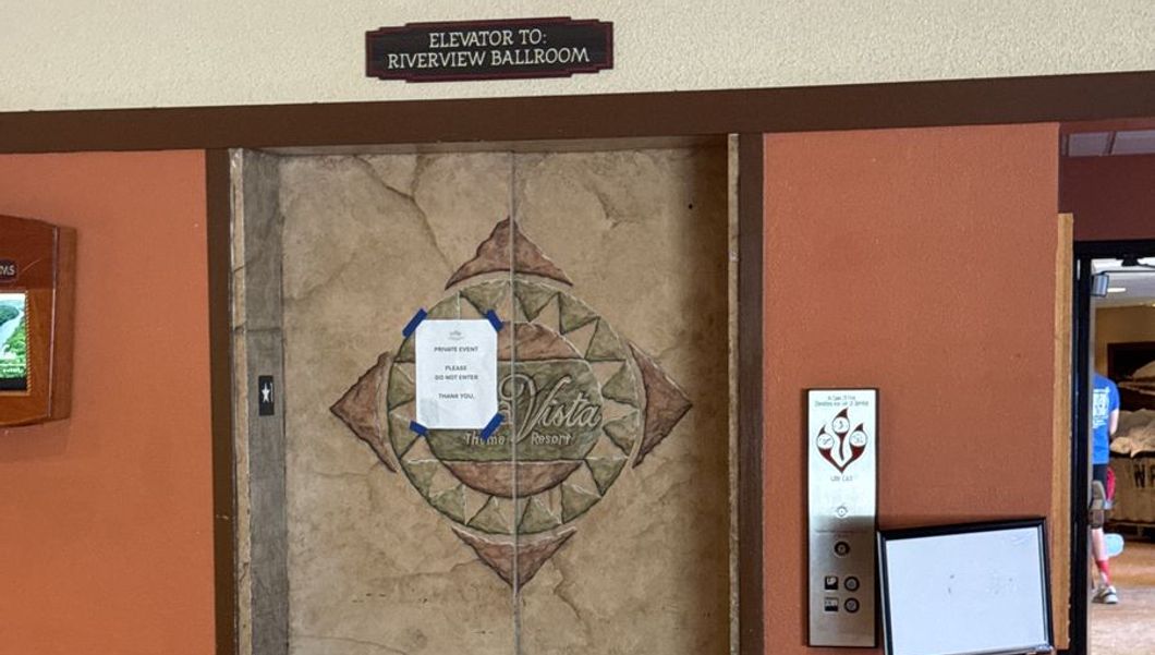 The elevator doors with the sign "Elevator to: Riverview Ballroom" above them and a private event notice taped to the door. Press L inside for the lower level.